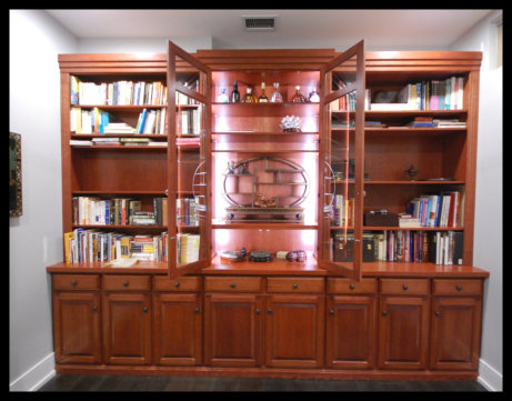 14ft cherry secretary; 8 raised panel doors, 8 drawers, center glass doors with LED lighting, and flanking bookcases.