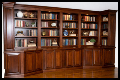16ft cherry floor-to-ceiling library; 6 bays of open shelving with fluted moldings and custom angled corners; solid wood.