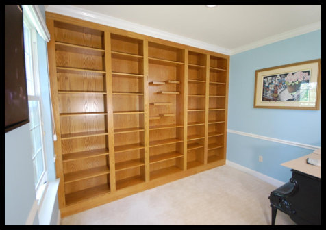 Custom 5-tier Red Oak built-in bookcase with a specialized center section featuring floating shelving.