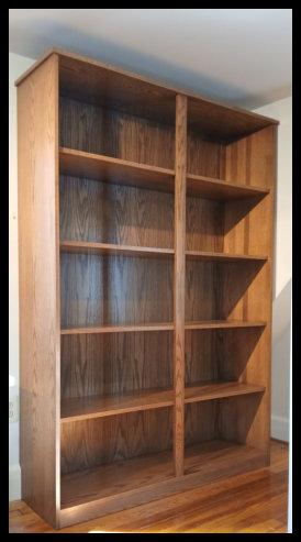 Twin Red Oak freestanding bookcase and vinyl record cabinet with a solid tabletop and finished side panel, designed as a portable built-in solution.