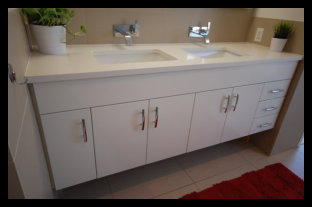 Premier showcase of a custom white floating bathroom vanity featuring five doors, three drawers, and a premium double bowl inlaid sink.