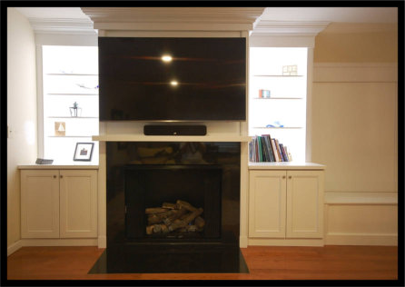 Custom 14ft wide home entertainment center featuring handcrafted solid wood cabinetry and built-in bookcases flanking a central fireplace.