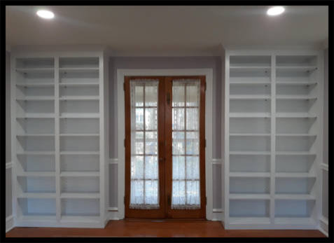 Twin white Maple built-in bookcases flanking double entry French doors with adjustable veneer core shelving.