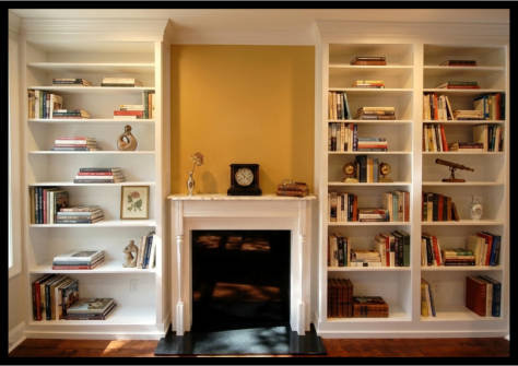 Custom white Maple floor-to-ceiling built-in bookcases with high baseboards and decorative crown molding.